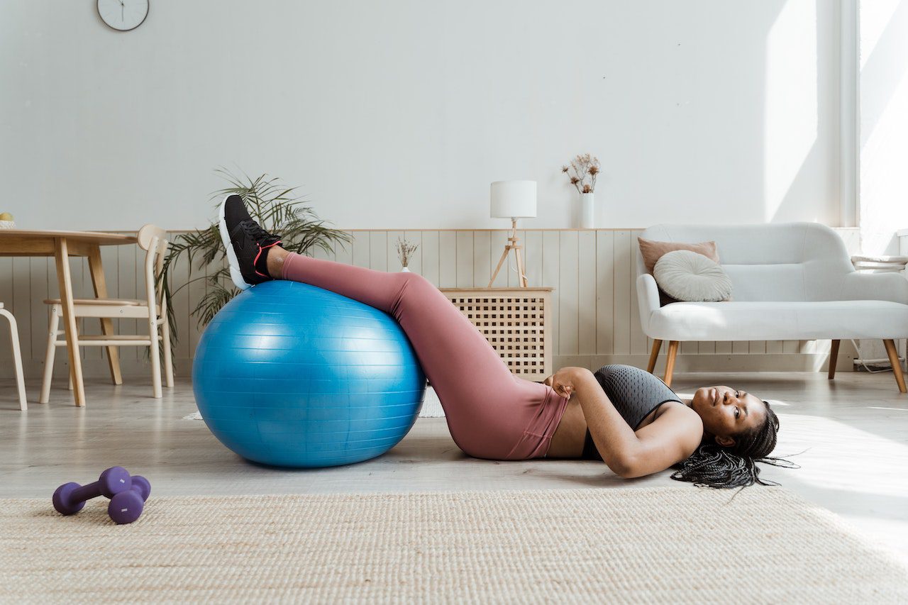 Vrouw met voeten op blauwe balance ball sport thuis