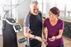 Oudere man en vrouw kijken samen naar eGym app