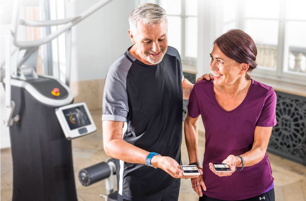 Oudere man en vrouw kijken samen naar eGym app