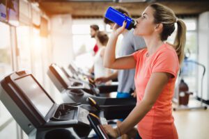 Vrouw drinkt water in goedkope sportschool in de buurt