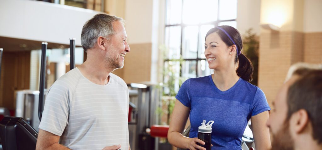 Man en vrouw kijken vrolijk na samen voltooien milon cirkel workout